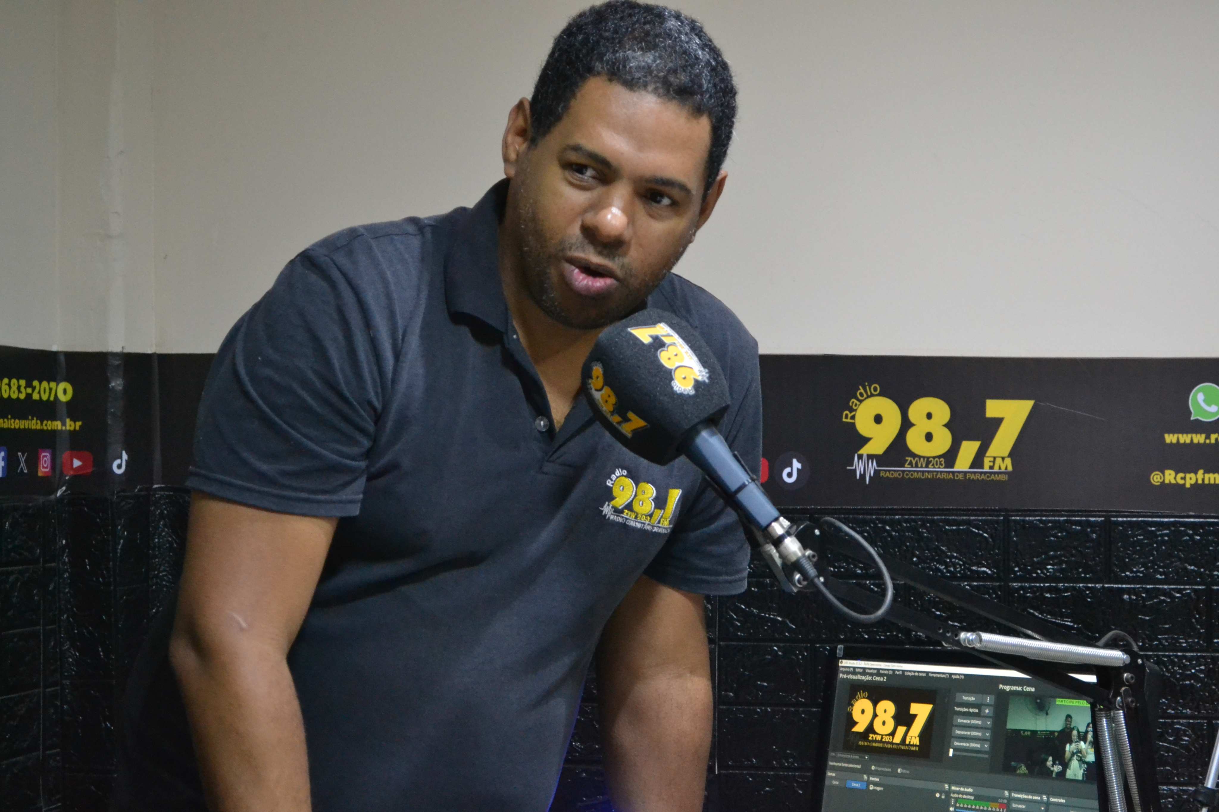 No estúdio da 98.7 FM, Rudson Santana, um dos fundadores da Rádio Comunitária de Paracambi, conduz mais uma transmissão ao vivo. Sua atuação diária reflete o compromisso da emissora com a informação local e a escuta ativa da comunidade. / Ana Cezário